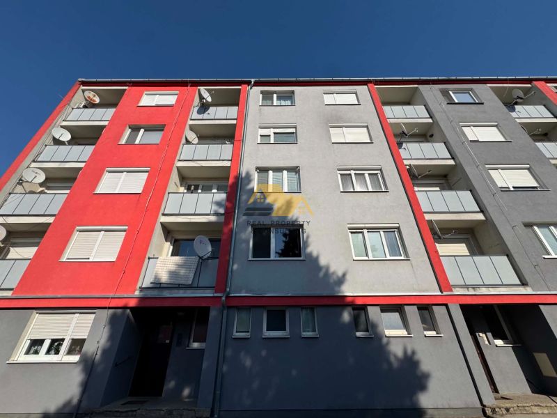 Colorful facade of a 3-room apartment building on the street in Bajč with satellites.