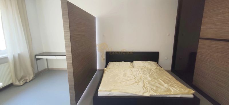 Bedroom with a bed and a desk in a 2-room apartment.