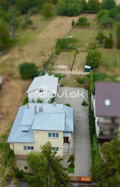 A family house on Topolianska Street in Michalovce with a garden and an adjacent building.