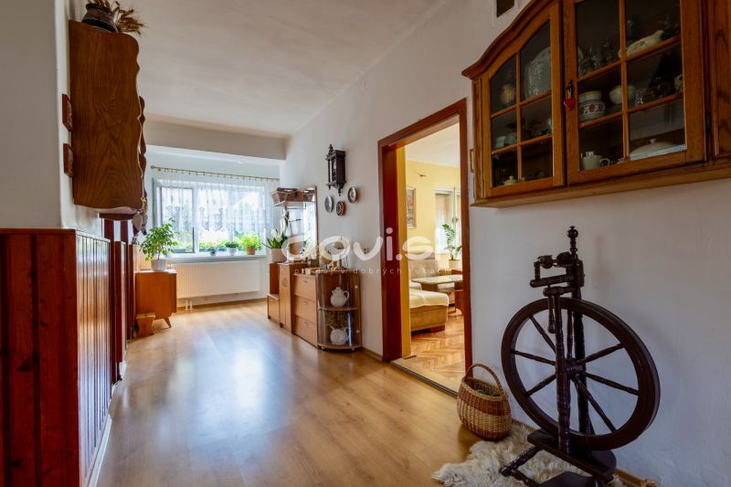 A hallway of a family house with a wooden decor floor, furniture, and decorations.