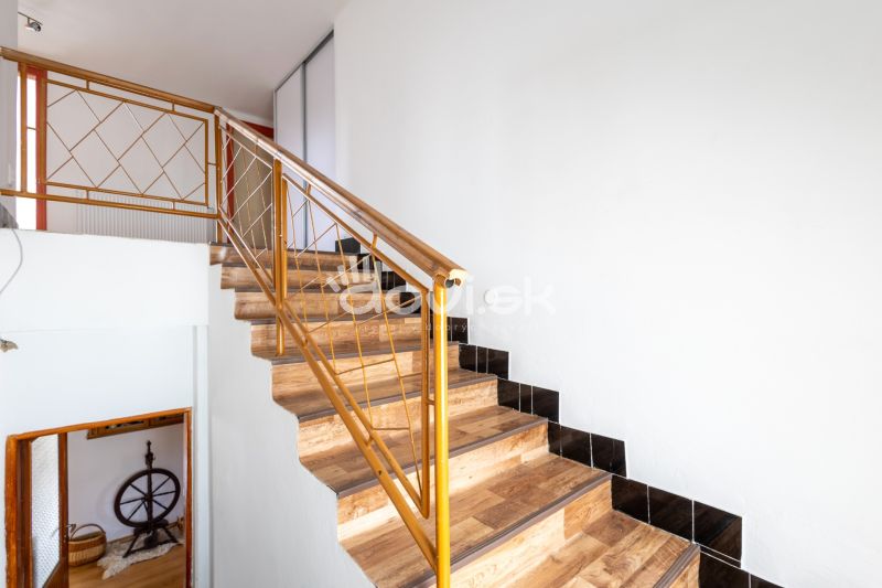 A staircase with a wooden decor floor and metal railing in a family house.