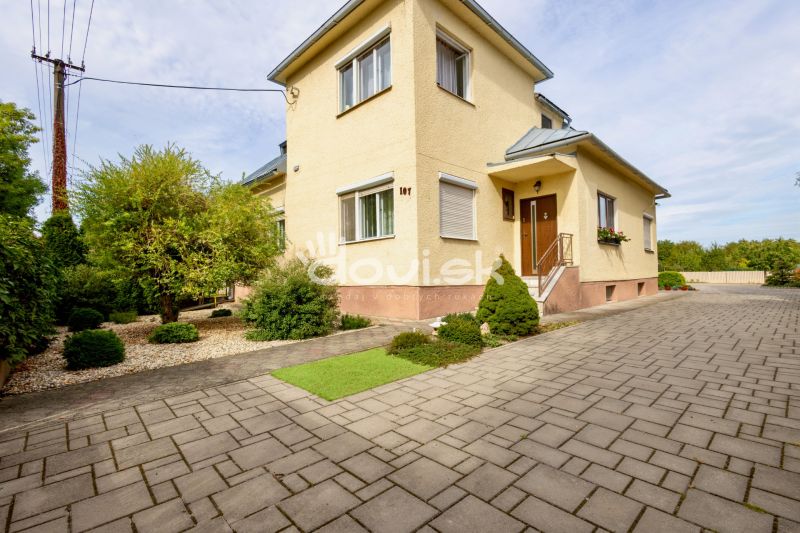 A family house on Topolianska Street in Michalovce with a landscaped garden and paving.