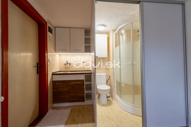 A bathroom in a family house with a bathtub, a sink, and a floor with a wooden decor.