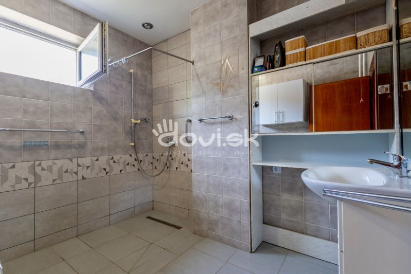 A bathroom with an open shower and a sink in a family house.