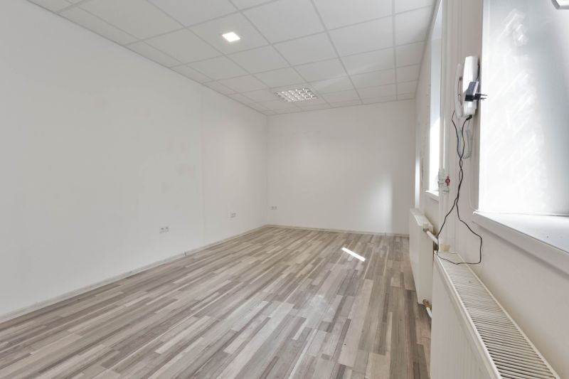 Interior of commercial spaces with white walls and a floor with a wood decor.