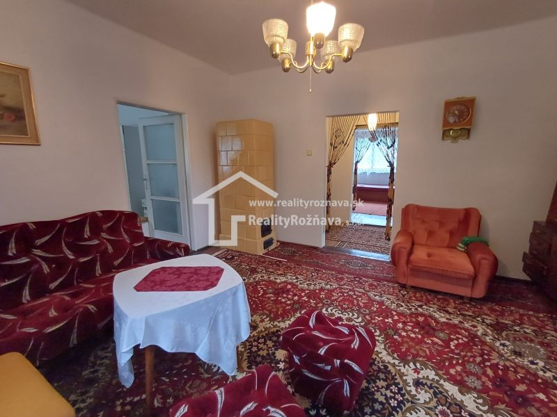 Living room in a family house with retro furniture and a tiled stove.