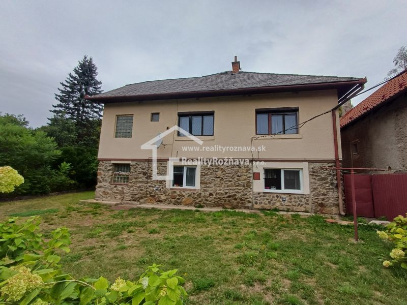 A family house in Drnava with a stone facade and a grassy garden in a fresh environment.