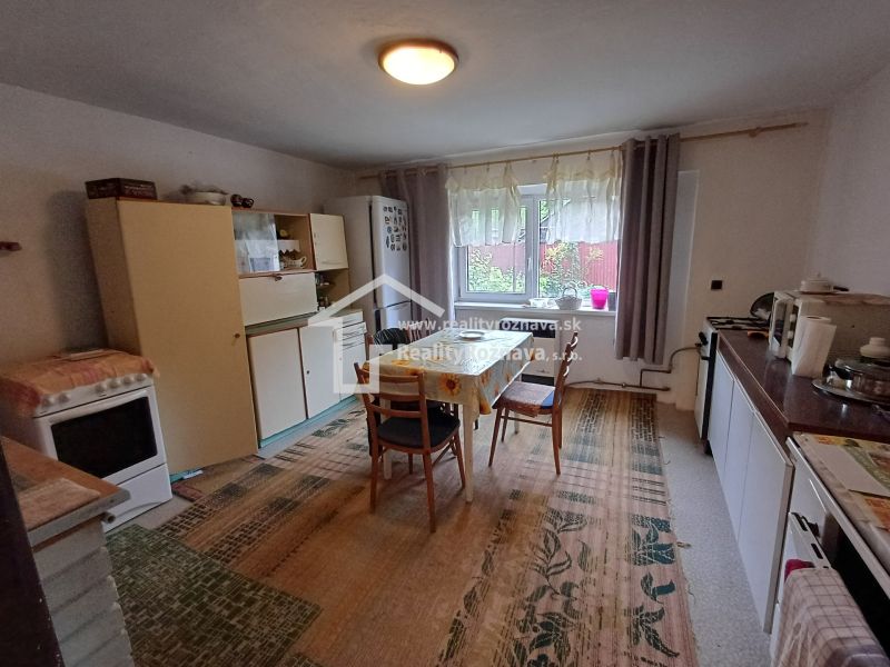 A kitchen in a family house with a dining table, equipped with white cabinets.