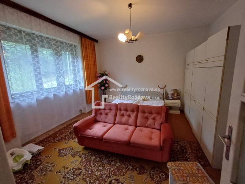 Living room in a family house with a sofa, carpet, and wall cabinet.