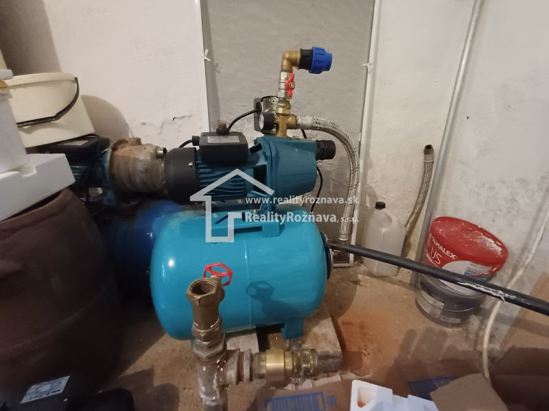 A water facility in the basement of a family house, surrounded by various equipment.