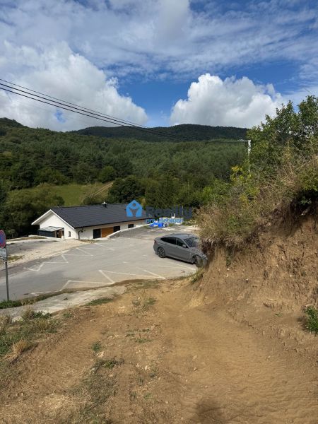 Plots - housing in Považská Bystrica with a view of wooded hills and a road.