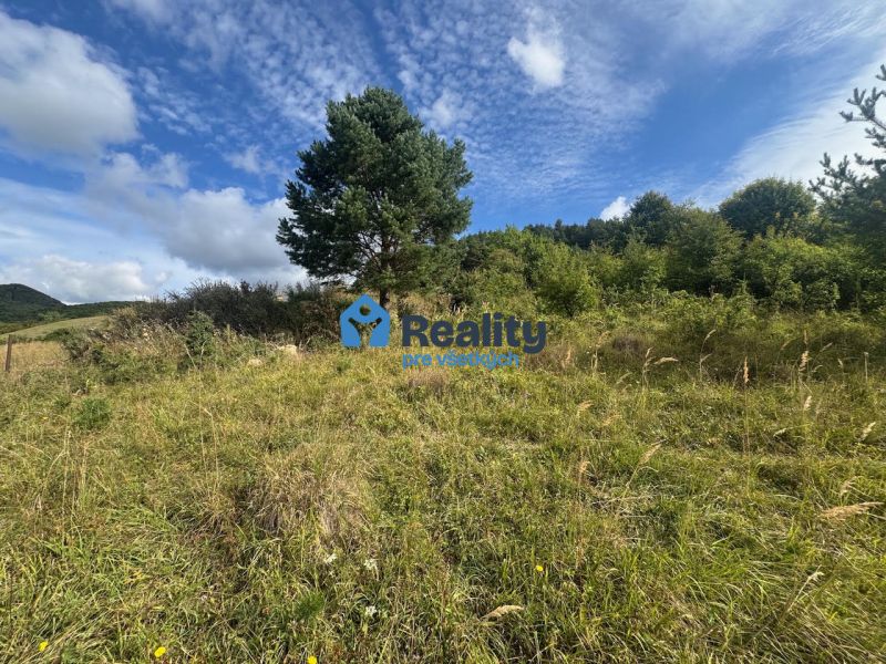 A plot for residential use in Považská Bystrica surrounded by greenery and blue skies.