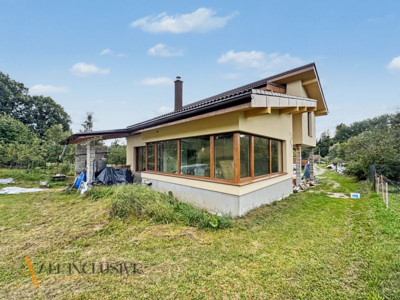 A family house in Veličná with a spacious garden surrounded by greenery and a blue sky.