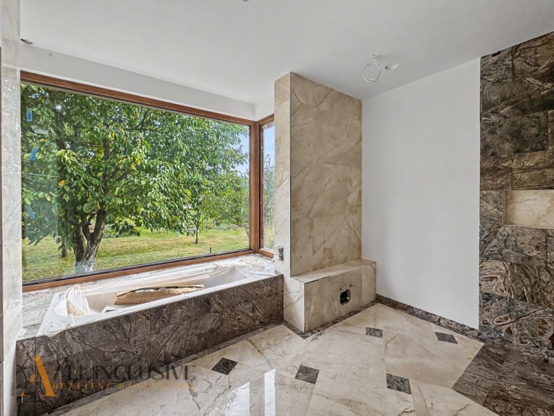 Family house bathroom with a large window and a view of the garden.