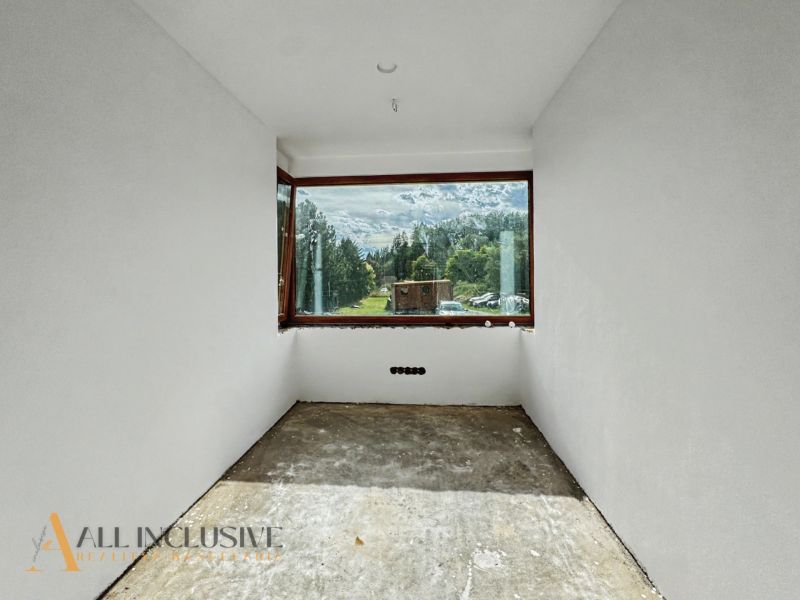 A view from a family house through a large window of the mountains and greenery.