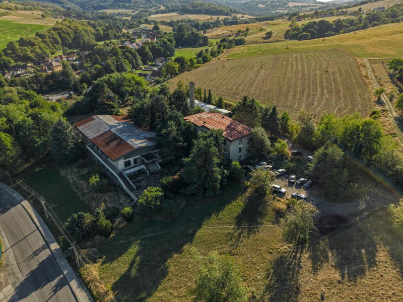 Aerial view of development plots in Slatinské Lazy with an old building and nature.