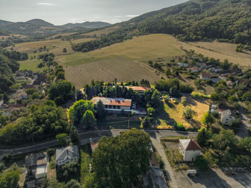 Aerial view of development plots in Slatinské Lazy, surrounded by hilly landscape.