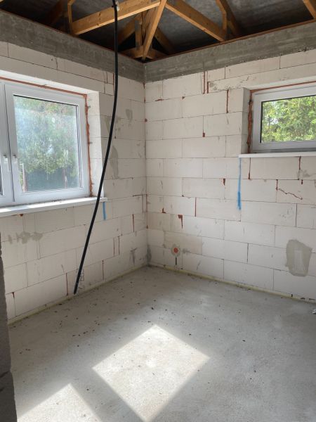 The construction of a room in a family house, white bricks and windows provide light.