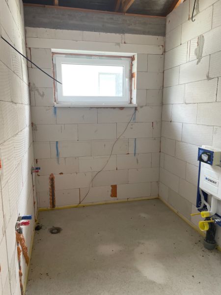 A bathroom under construction in a family house without a finished floor and tiles.