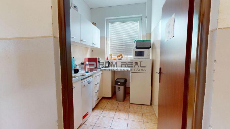 Offices with a furnished kitchenette, including appliances and storage space.
