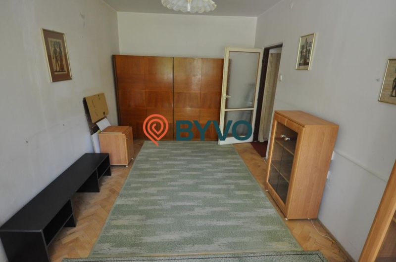 A room in a 3-room apartment with a carpet, cabinets, and a floor with a wood decor.