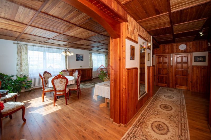 A dining room in a family house with a wood-patterned floor and wooden paneling.