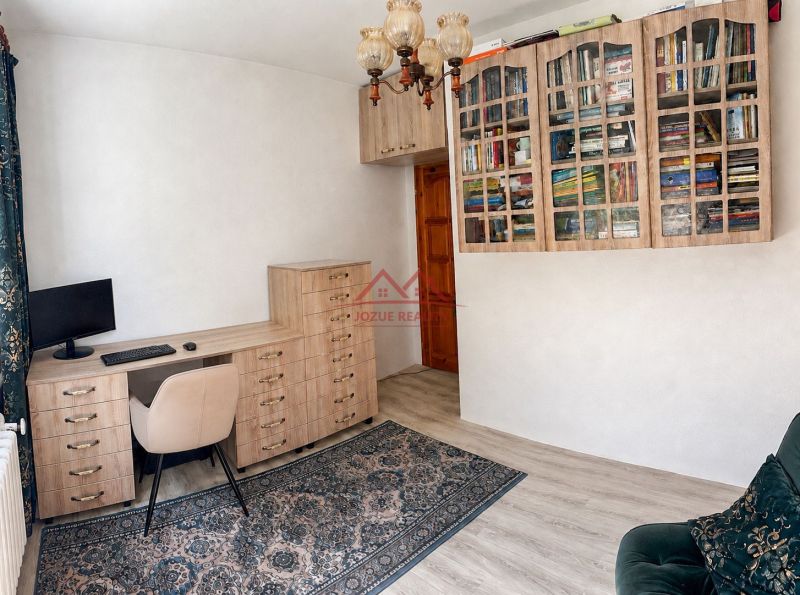 A study in a family house with a wooden decor floor and a bookshelf.