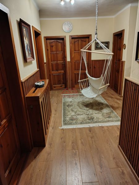 Interior of a family house with a swing, wooden doors, and a floor with a wooden decor.