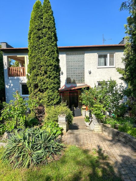 A family house in Sady nad Torysou with a well-maintained garden and pathway, surrounded by greenery.