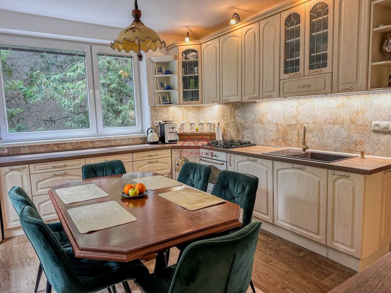 A kitchen in a family house with a wooden decor floor and a dining table.