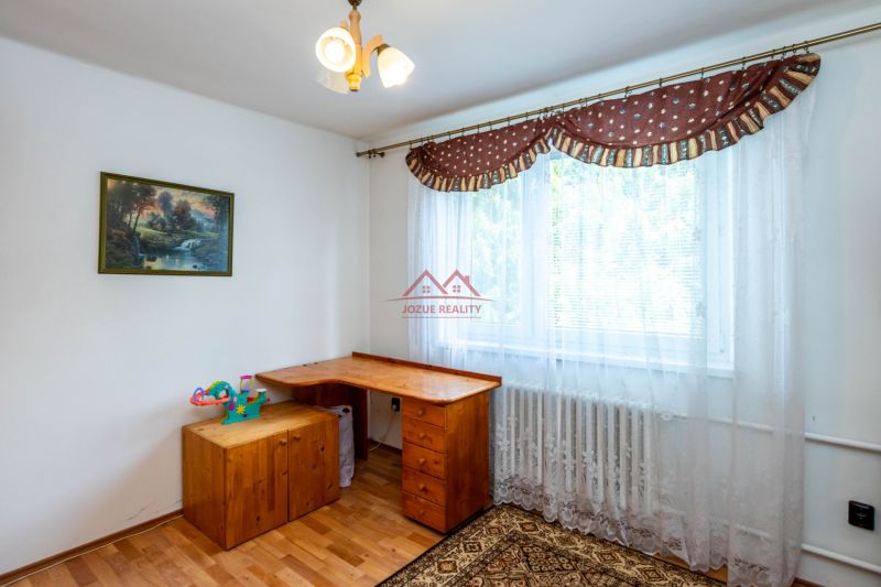 Interior of a family house with a wooden table next to the window and decoration on the wall.