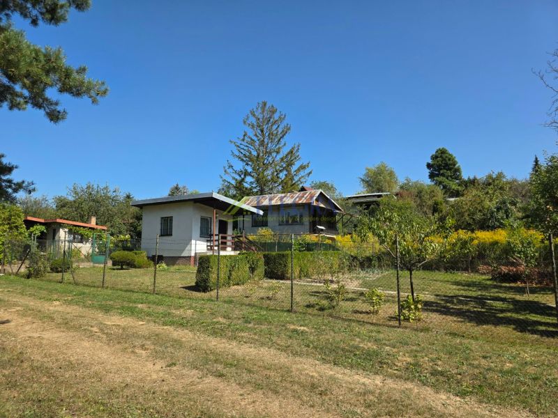 A cottage on Popradská Street in Košice West surrounded by greenery and a grassy plot.