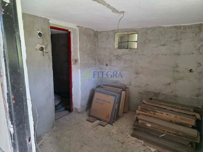 A cabin with unfinished walls and tiles on the floor with a wood design.