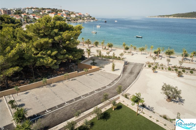 A view of a seaside recreational apartment in Sevid with trees and parking by the beach.