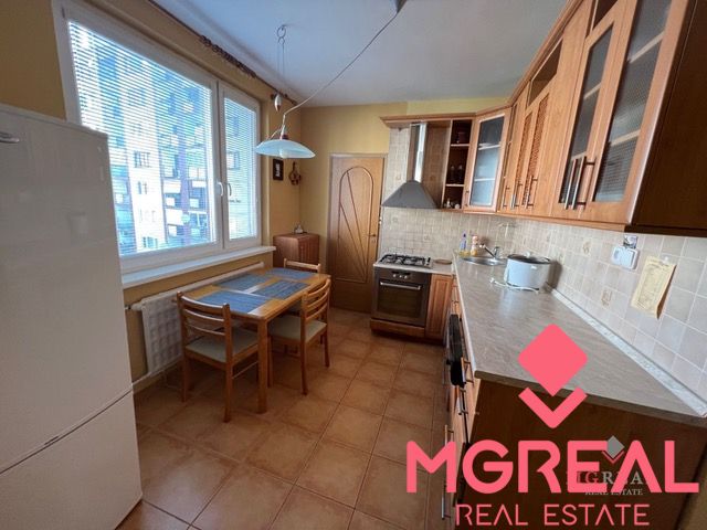 A kitchen in a 3-room apartment with a wooden decor and a dining table.