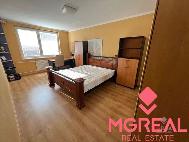 A bedroom with wooden furniture and a floor with a wood decor in a 3-room apartment.