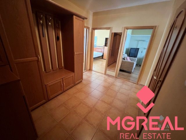 A hallway in a 3-room apartment with ceramic tiles and wooden furniture.