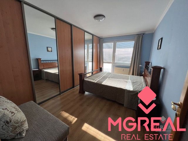 A bedroom in a 3-room apartment with a wood-patterned floor and a large wardrobe.