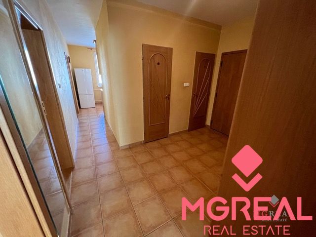 A hallway in a 3-room apartment with light-colored doors and tiled flooring.