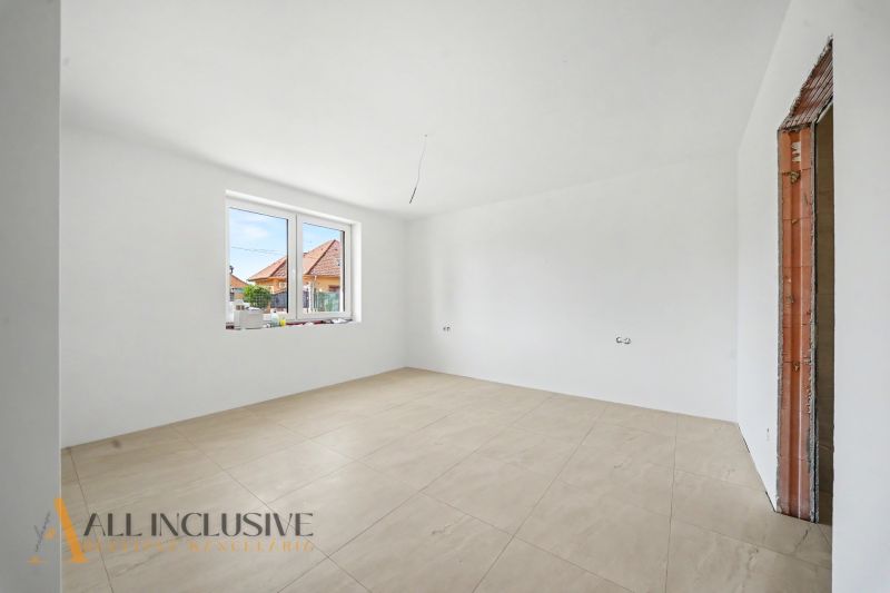 Spacious room in a family house with white walls and light tiles.