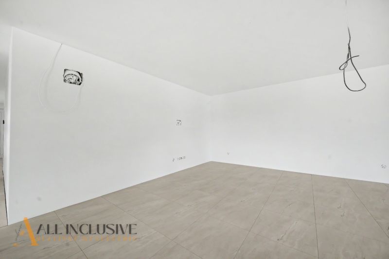 An empty room with white walls and a floor with a wooden decor in a family house.