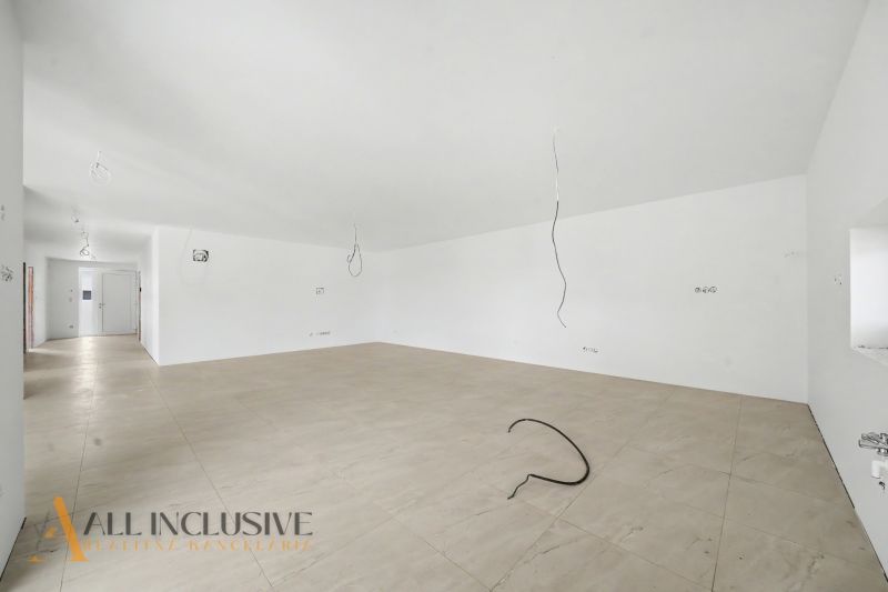 A spacious room with white walls and a floor with a wooden decor in a family house.