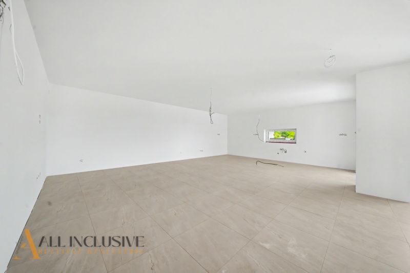 A spacious room with a wooden decor floor in a family house.