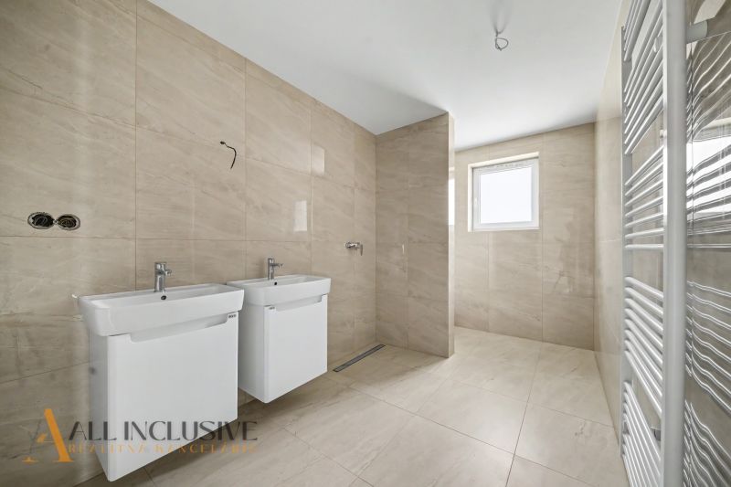 A bathroom in a family house with two sinks and ceramic tiles.