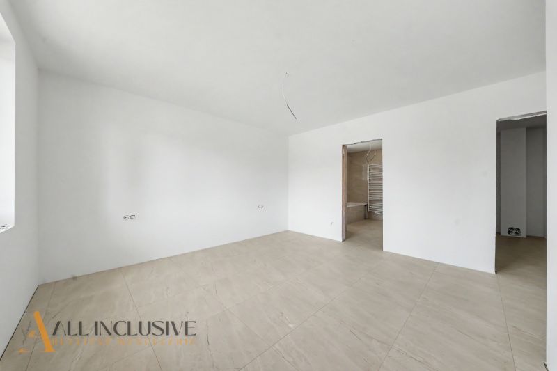 A spacious room with white walls and a light floor in a family house.