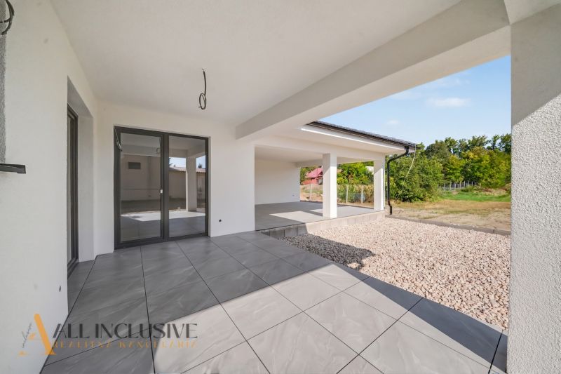 The terrace of a family house in Tomášikovo with gray paving and a garden in the background.