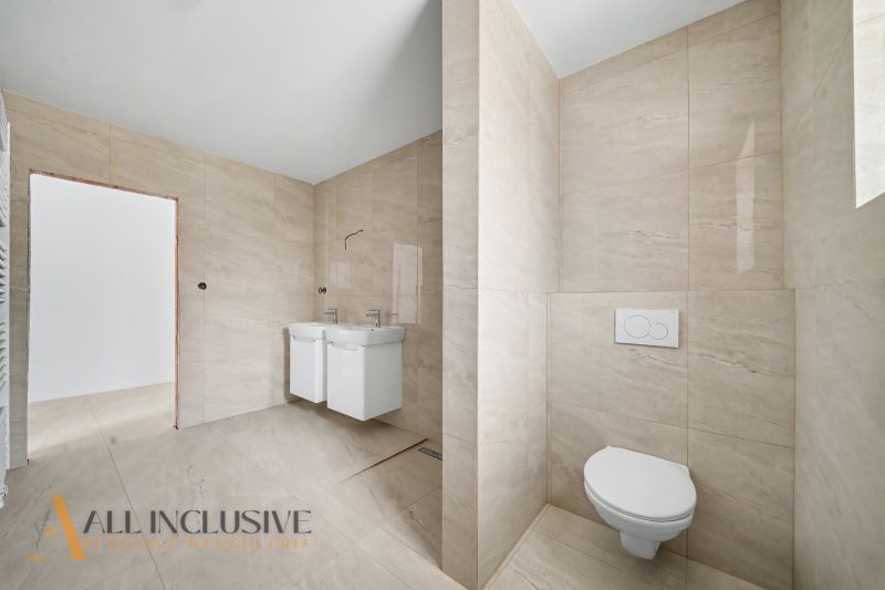 A bathroom with ceramic tiles and a double sink in a family house.