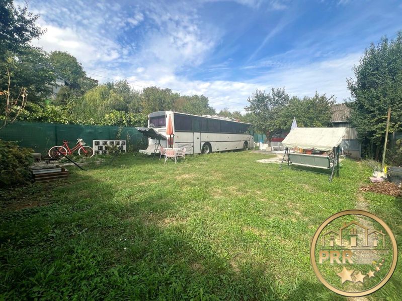 The garden at the cottage in Bánovce nad Bebravou with a bus, bicycle, and swing.