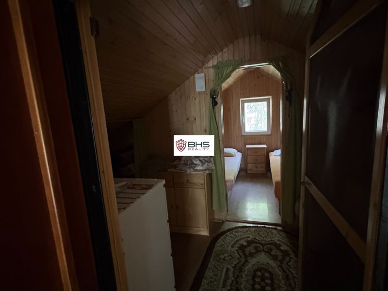 Interior of a cabin with two beds and a window, floor with wooden decor.