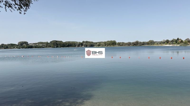 A lake with buoys surrounded by greenery in Bodíky.